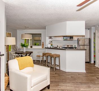 An open kitchen and living room with a couch and a table
